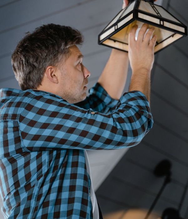 Electrician installing ceiling light fixture professionally
