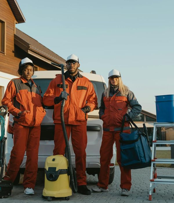 Team of professional handymen posing with their tools and equipment